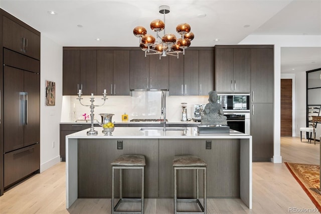 155 Steele St Unit 418, Denver, CO 80206 - kitchen with built in fridge, light countertops, stainless steel oven, dark brown cabinetry, and recessed lighting