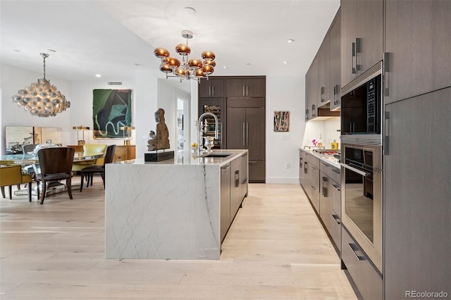 155 Steele St Unit 418, Denver, CO 80206 - kitchen featuring a chandelier, appliances with stainless steel finishes, modern cabinets, light wood finished floors, and recessed lighting