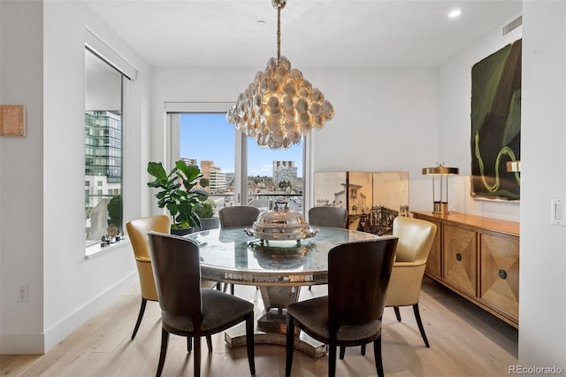 155 Steele St Unit 418, Denver, CO 80206 - dining area with light wood-type flooring, a chandelier, and baseboards
