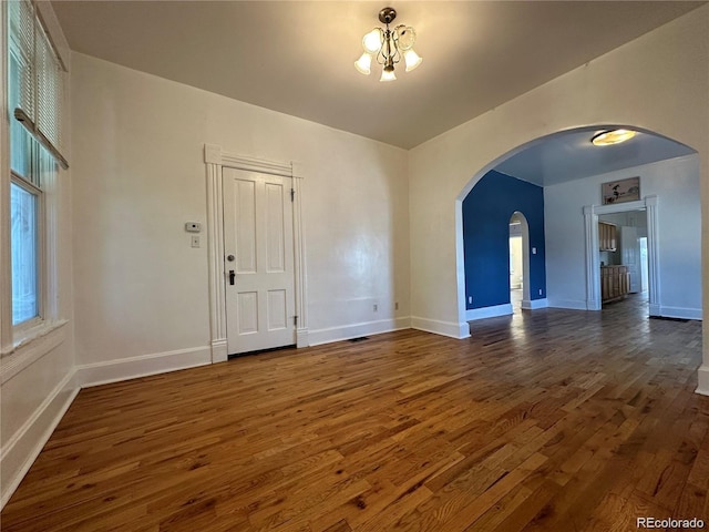 interior space with dark wood-type flooring and a chandelier