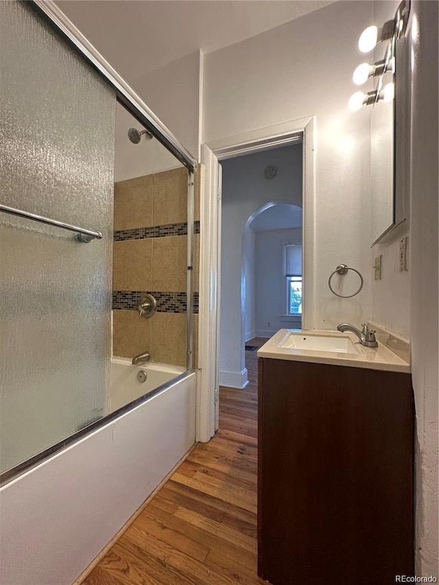 bathroom with vanity, bath / shower combo with glass door, and hardwood / wood-style floors