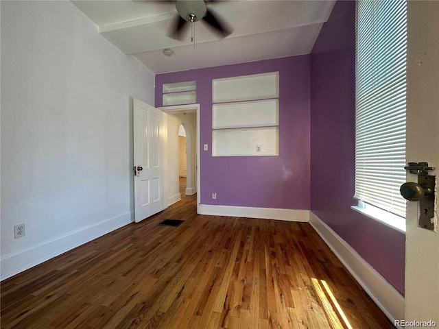 unfurnished room with ceiling fan, built in features, and wood-type flooring