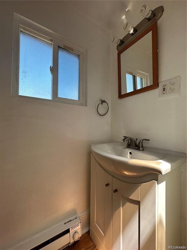 bathroom with hardwood / wood-style floors, a baseboard radiator, and vanity