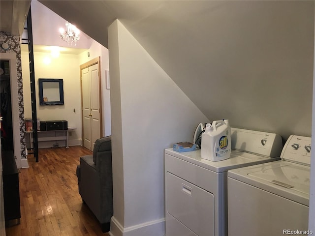 laundry area featuring independent washer and dryer, hardwood / wood-style flooring, and a chandelier