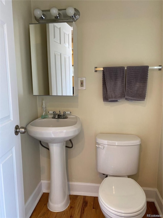 bathroom featuring wood-type flooring and toilet