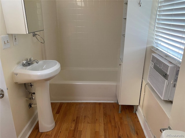 bathroom with hardwood / wood-style flooring,  shower combination, and cooling unit