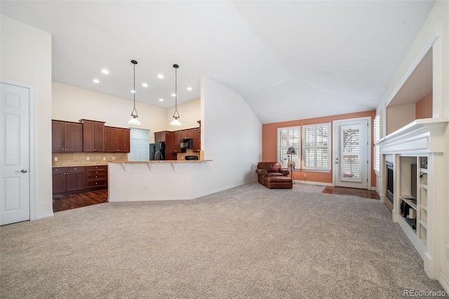 unfurnished living room with lofted ceiling and dark carpet