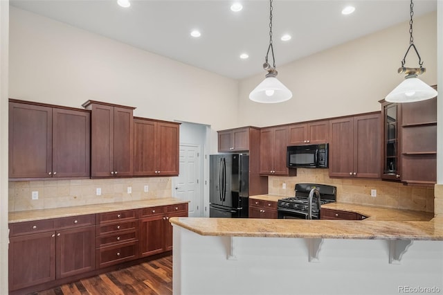 kitchen with pendant lighting, a kitchen breakfast bar, black appliances, and kitchen peninsula