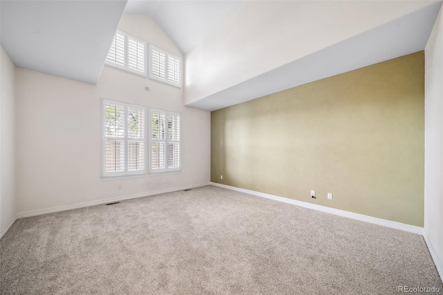 empty room with carpet flooring and high vaulted ceiling