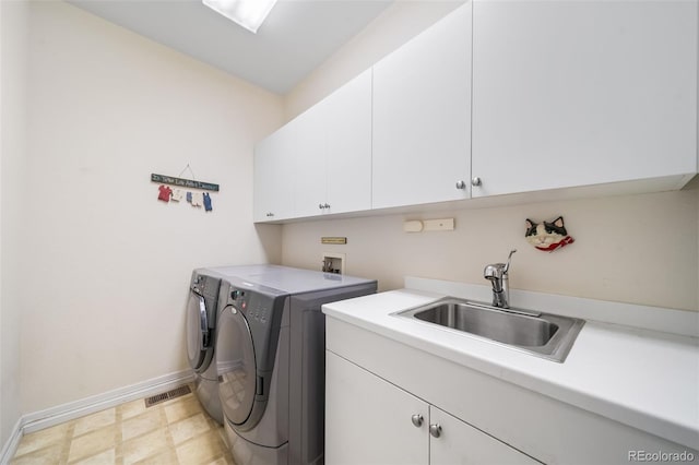 washroom with cabinets, sink, and washing machine and clothes dryer