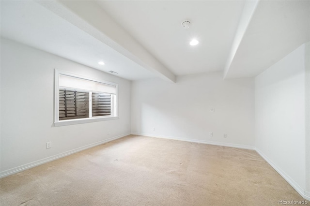 unfurnished room featuring beamed ceiling and light carpet