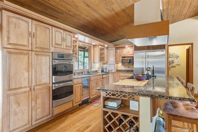 kitchen with built in appliances, wine cooler, a kitchen island, a breakfast bar, and light hardwood / wood-style floors