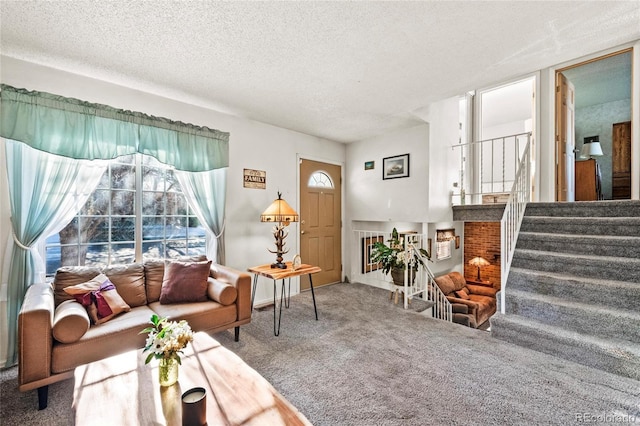 carpeted living area with a healthy amount of sunlight, stairway, and a textured ceiling