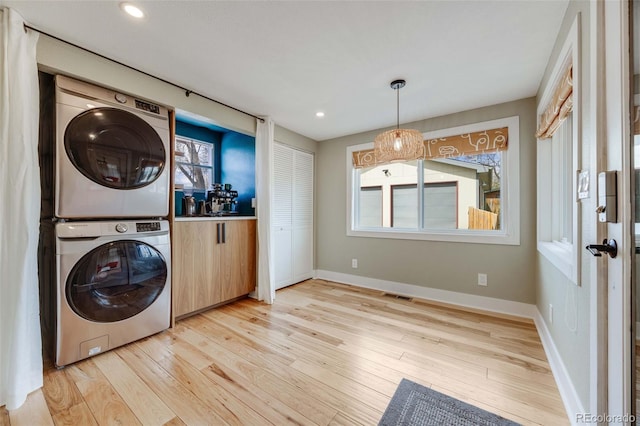 1055 Quartz St, Golden, CO 80401 - washroom featuring stacked washing machine and dryer, light wood-type flooring, baseboards, and recessed lighting