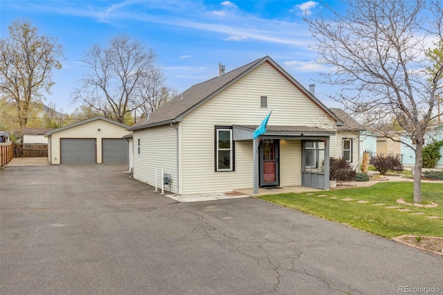1055 Quartz St, Golden, CO 80401 - bungalow featuring a detached garage, roof with shingles, an outbuilding, and a front lawn