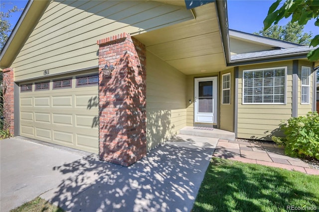 entrance to property with driveway and an attached garage