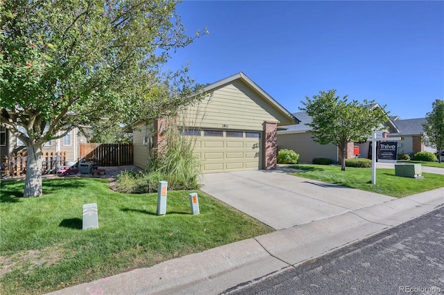 view of front of property featuring a front lawn, fence, an attached garage, and concrete driveway