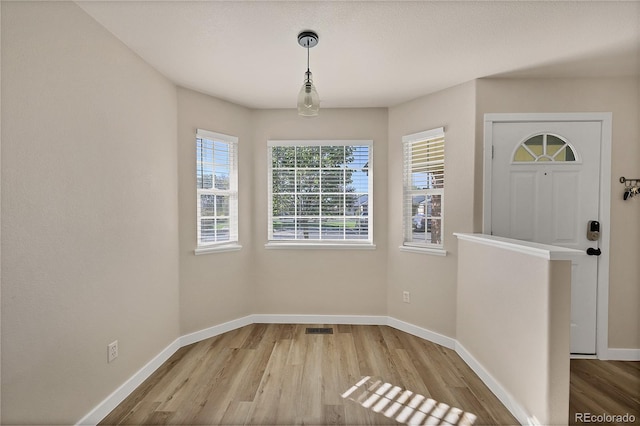 foyer with visible vents, baseboards, and wood finished floors