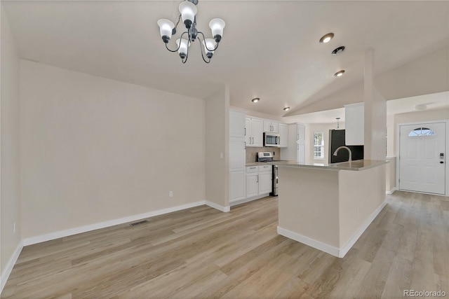 kitchen with vaulted ceiling, stainless steel appliances, light wood-style floors, visible vents, and white cabinets