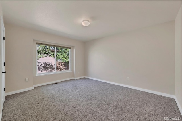 carpeted spare room with baseboards and visible vents