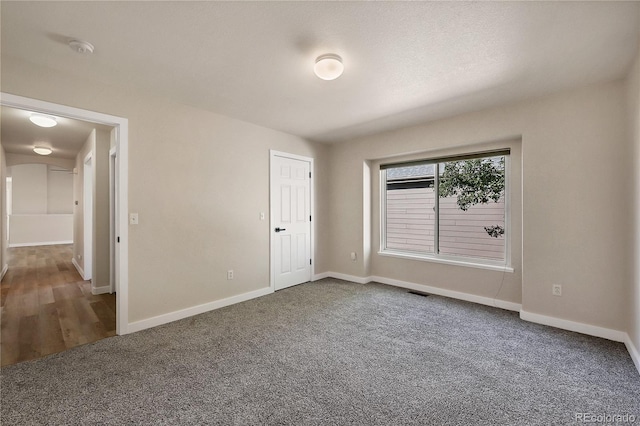 unfurnished bedroom featuring carpet flooring, baseboards, and visible vents
