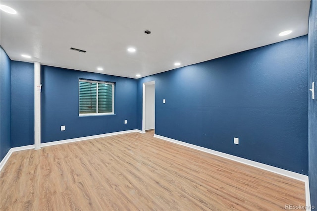 unfurnished room featuring baseboards, wood finished floors, and recessed lighting
