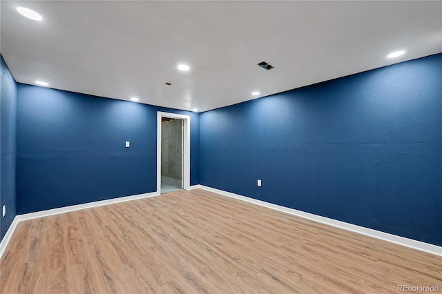 empty room featuring baseboards, wood finished floors, and recessed lighting