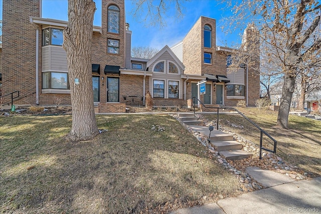 view of front of property featuring a front yard and brick siding