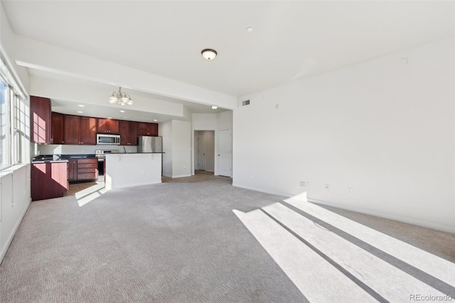 unfurnished living room with light carpet and a notable chandelier