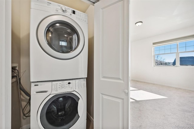 clothes washing area with carpet flooring and stacked washer / drying machine