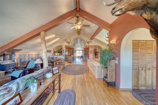 1120 County Road 322, Westcliffe, CO 81252 - living room with hardwood / wood-style floors, arched walkways, a ceiling fan, baseboards, and a wood stove