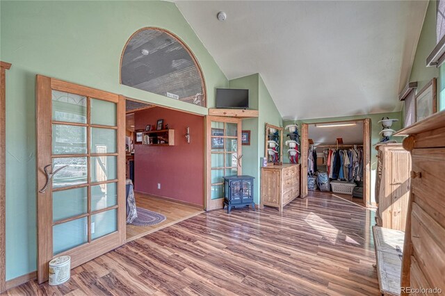 1120 County Road 322, Westcliffe, CO 81252 - living area featuring wood finished floors, a wood stove, high vaulted ceiling, and baseboards