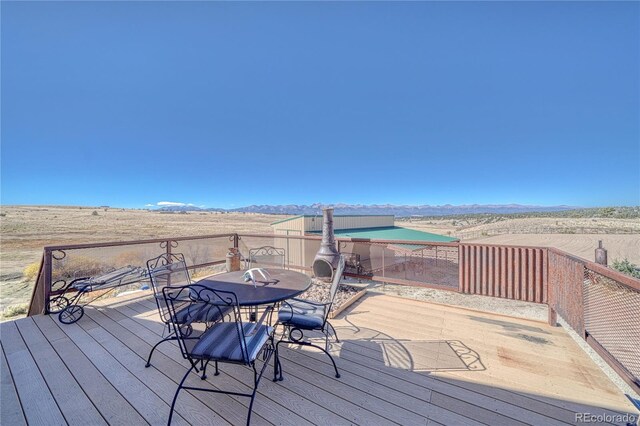 1120 County Road 322, Westcliffe, CO 81252 - wooden terrace with a mountain view and outdoor dining area