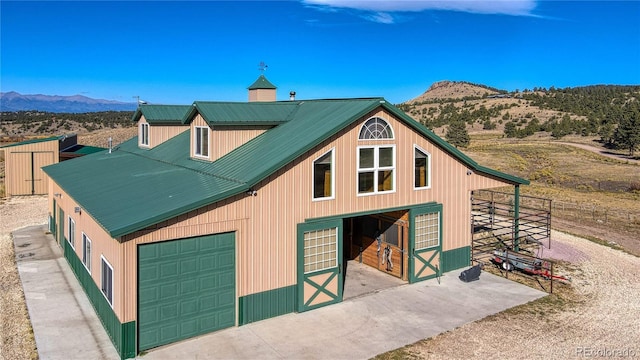 1120 County Road 322, Westcliffe, CO 81252 - view of front of property featuring an exterior structure, a mountain view, a garage, an outbuilding, and a chimney