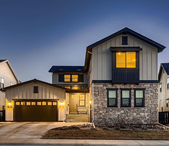 view of front facade featuring driveway, a standing seam roof, a garage, and board and batten siding