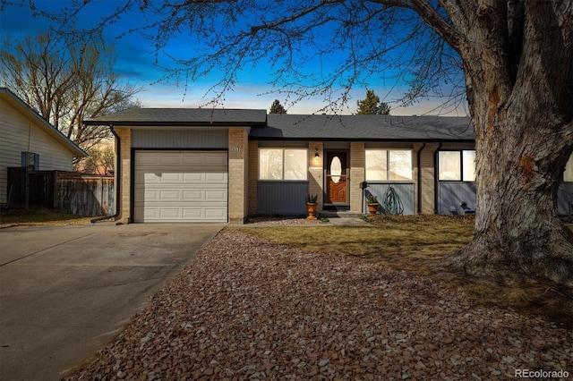 view of front of home featuring a garage, brick siding, roof with shingles, and driveway
