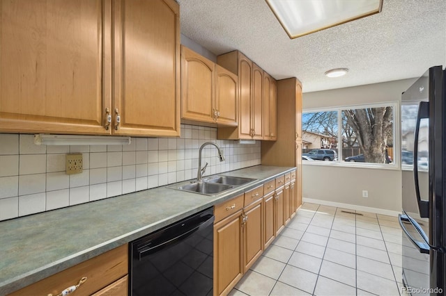 kitchen featuring black appliances, a sink, tasteful backsplash, light tile patterned floors, and baseboards