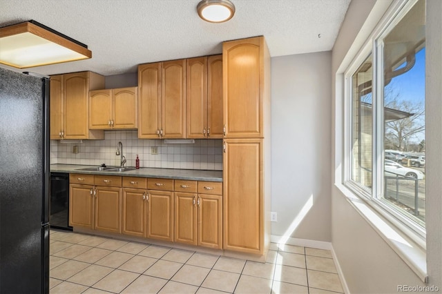 kitchen featuring baseboards, light tile patterned flooring, a sink, decorative backsplash, and black appliances