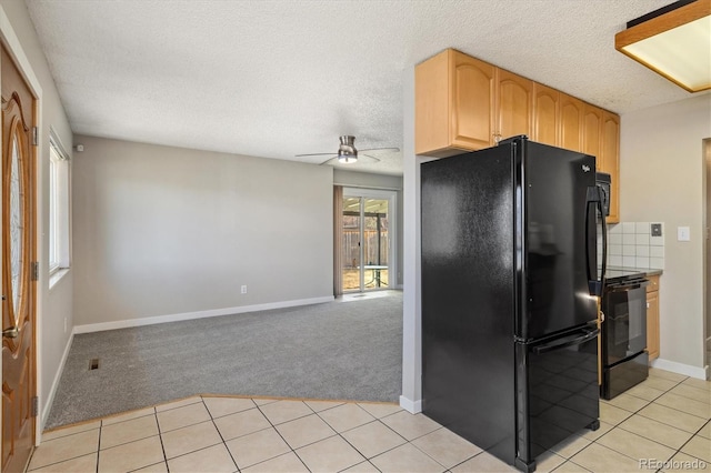 kitchen with light carpet, black appliances, light tile patterned flooring, and a ceiling fan