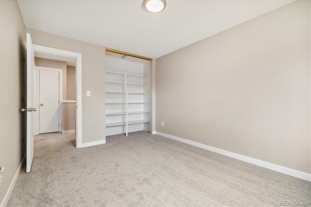 unfurnished bedroom featuring baseboards, a textured ceiling, and carpet flooring