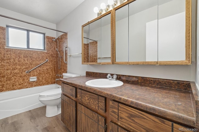 bathroom with shower / bathing tub combination, toilet, wood finished floors, and vanity