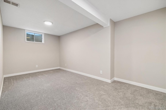 below grade area featuring carpet, visible vents, and baseboards