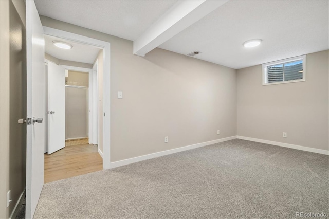 finished basement featuring baseboards, visible vents, and carpet floors