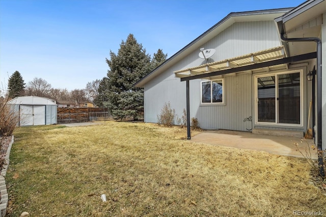 view of yard with a patio area, a storage unit, an outdoor structure, and fence