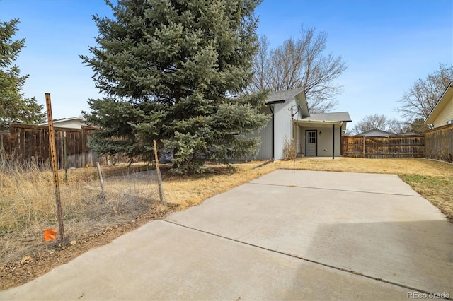 view of front of property featuring a patio and fence