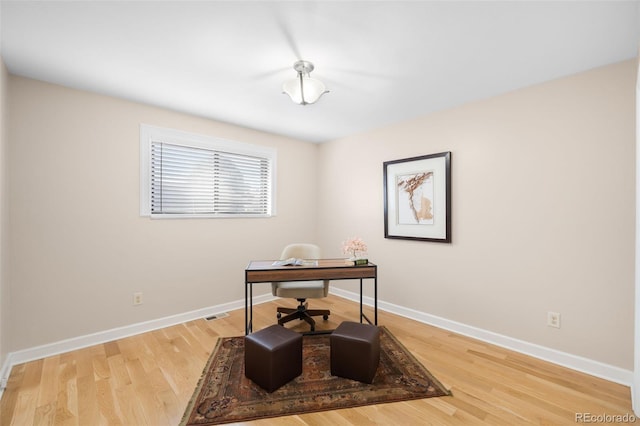 office featuring visible vents, baseboards, and wood finished floors