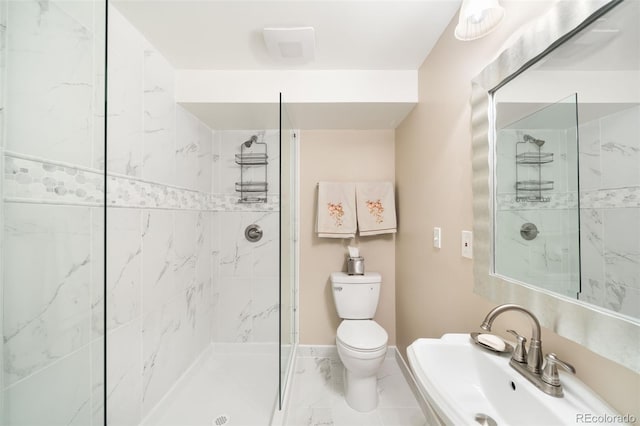 bathroom with marble finish floor, toilet, a sink, baseboards, and walk in shower