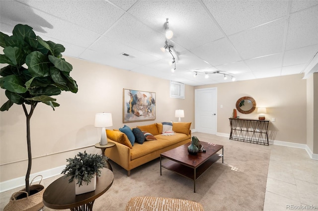 living room with a paneled ceiling, rail lighting, light tile patterned flooring, and baseboards