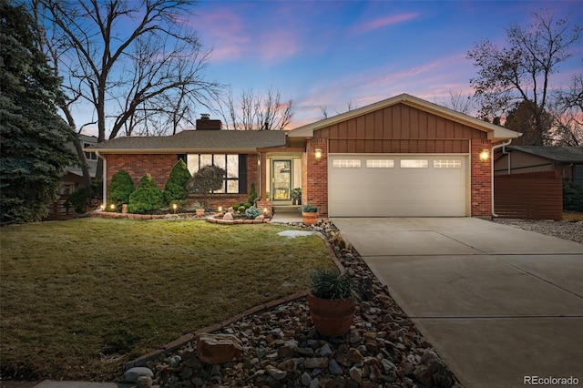 view of front of home featuring a front lawn, concrete driveway, and brick siding