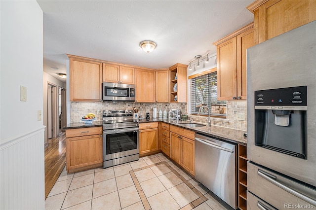 kitchen with light tile patterned floors, open shelves, a sink, stainless steel appliances, and tasteful backsplash